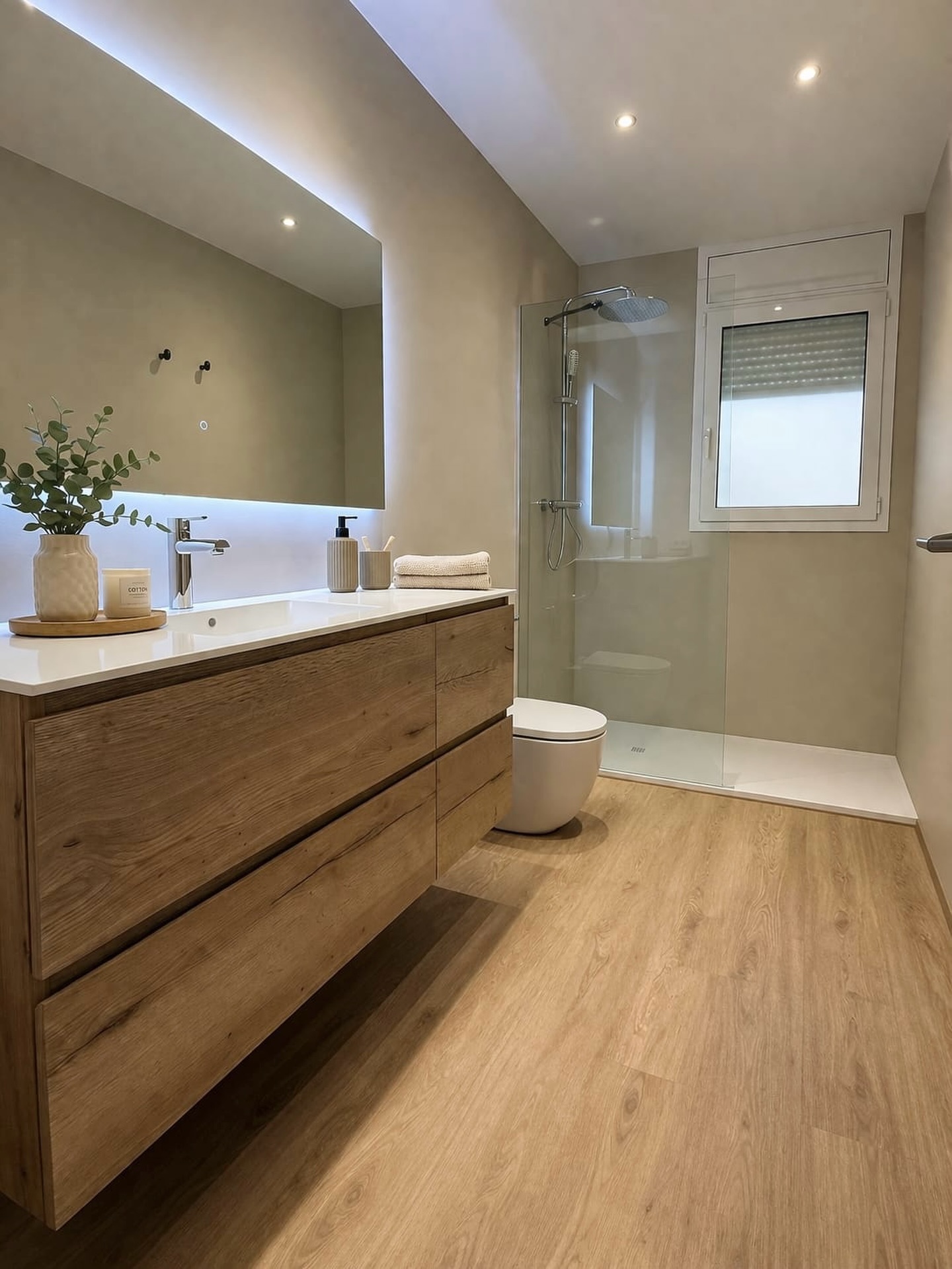 Baño cálido con madera, piedra y luz integrada